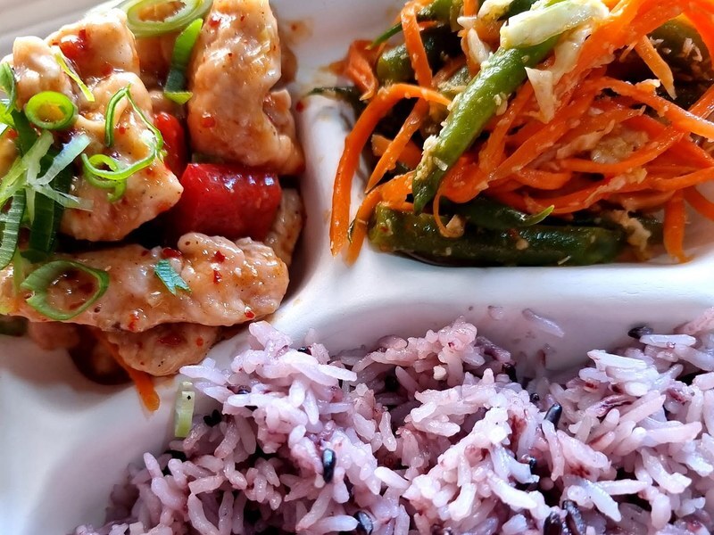 A Bento Deluxe box, glazed chicken with spring onion, green beans and shredded carrot, and purple rice